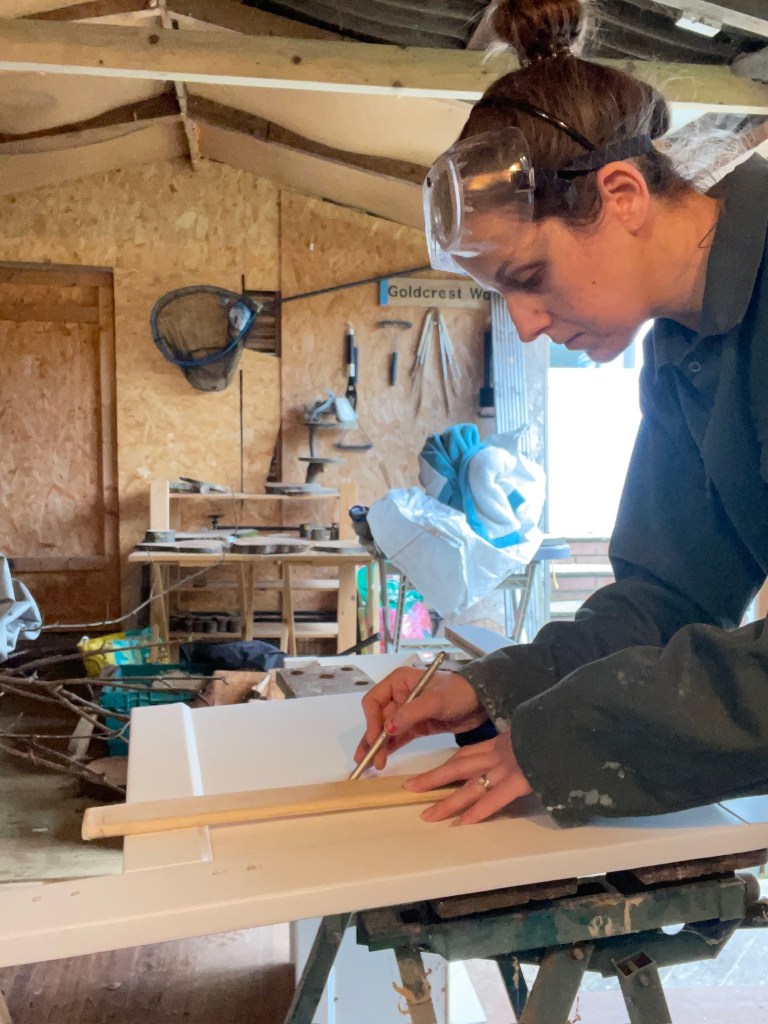Laser engraving a personalized wooden wedding sign at The Rustic Collection workshop in Bristol, UK